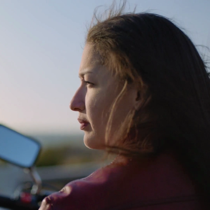 Woman sitting on motorcycle looking out | Pfizer clinical trials