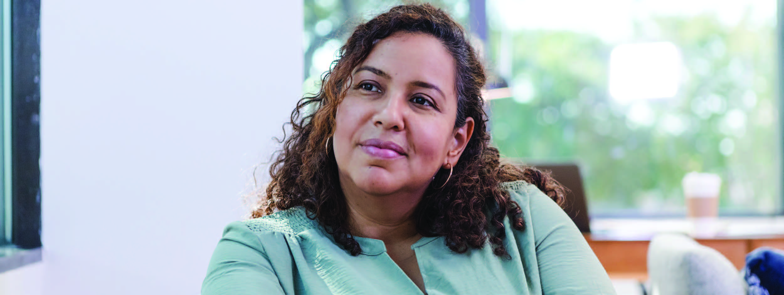 A woman sitting in a living room | Pfizer clinical trials