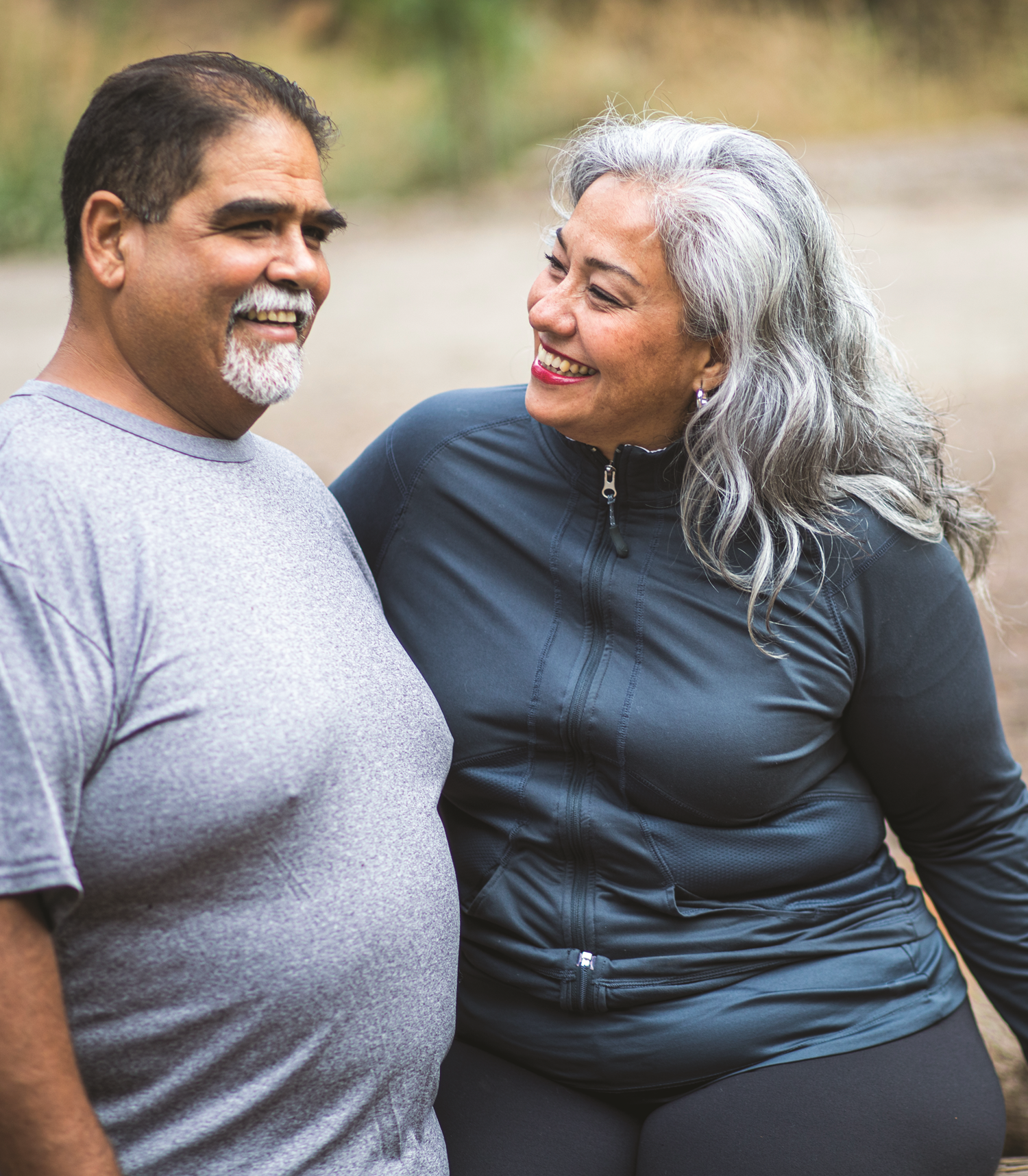 A man and woman enjoying a hike outdoors on a sunny day – Pfizer Clinical Trials
