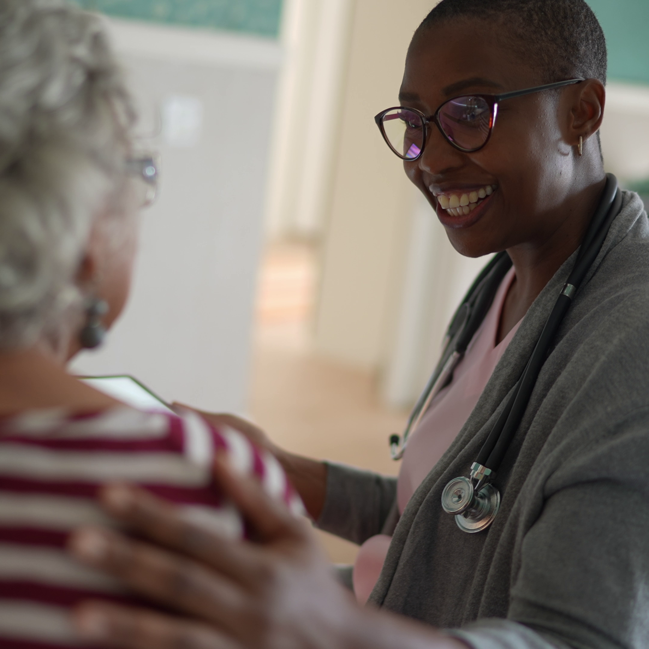 Smiling nurse treating participant in clinic.