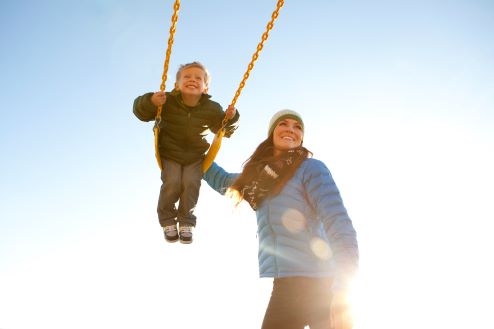 Woman with boy on a swing - Pfizer Clinical Trials