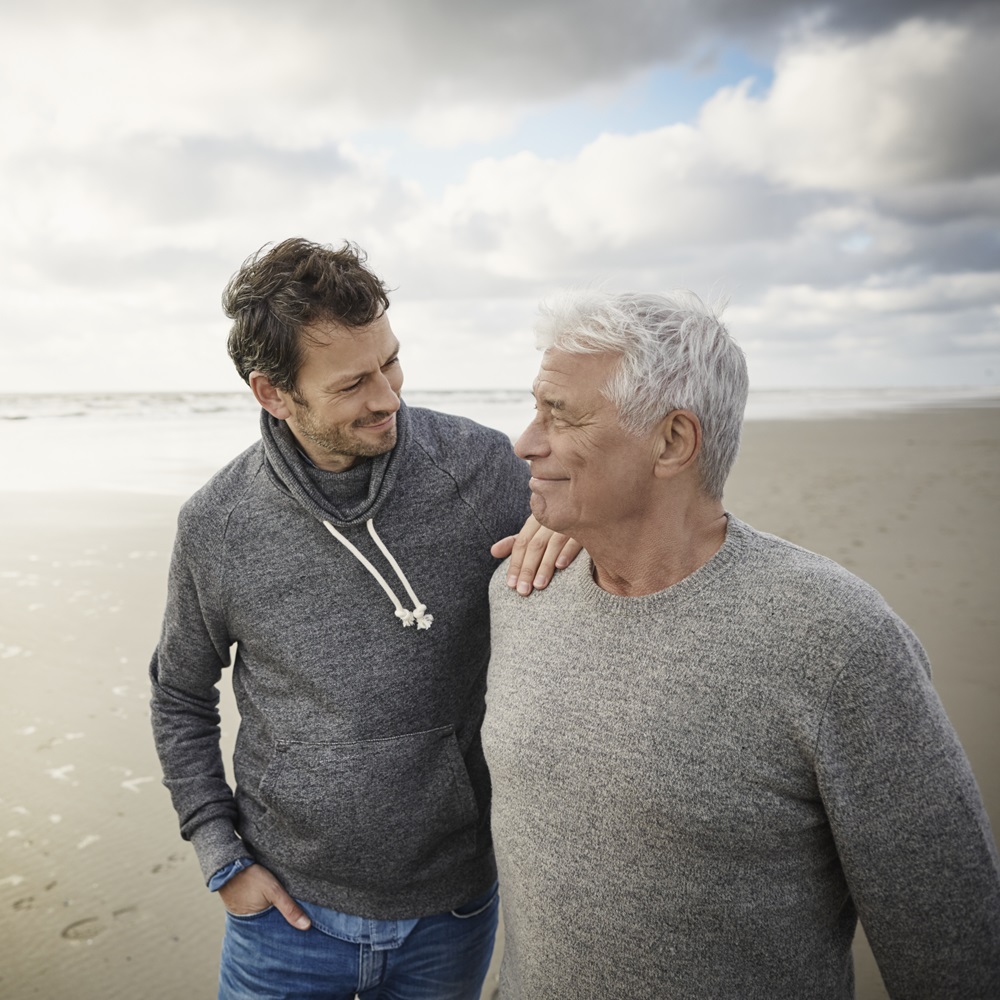 Father and son walking on beach | Pfizer clinical trials
