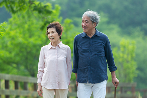 An older couple walking down a tranquil looking countryside path. – Pfizer Clinical Trials