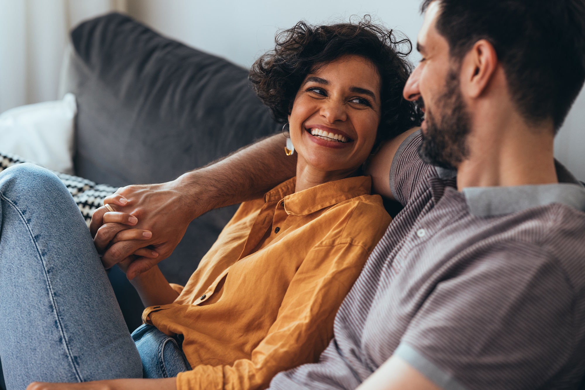 Happy couple sitting together on a cough | Pfizer clinical trials