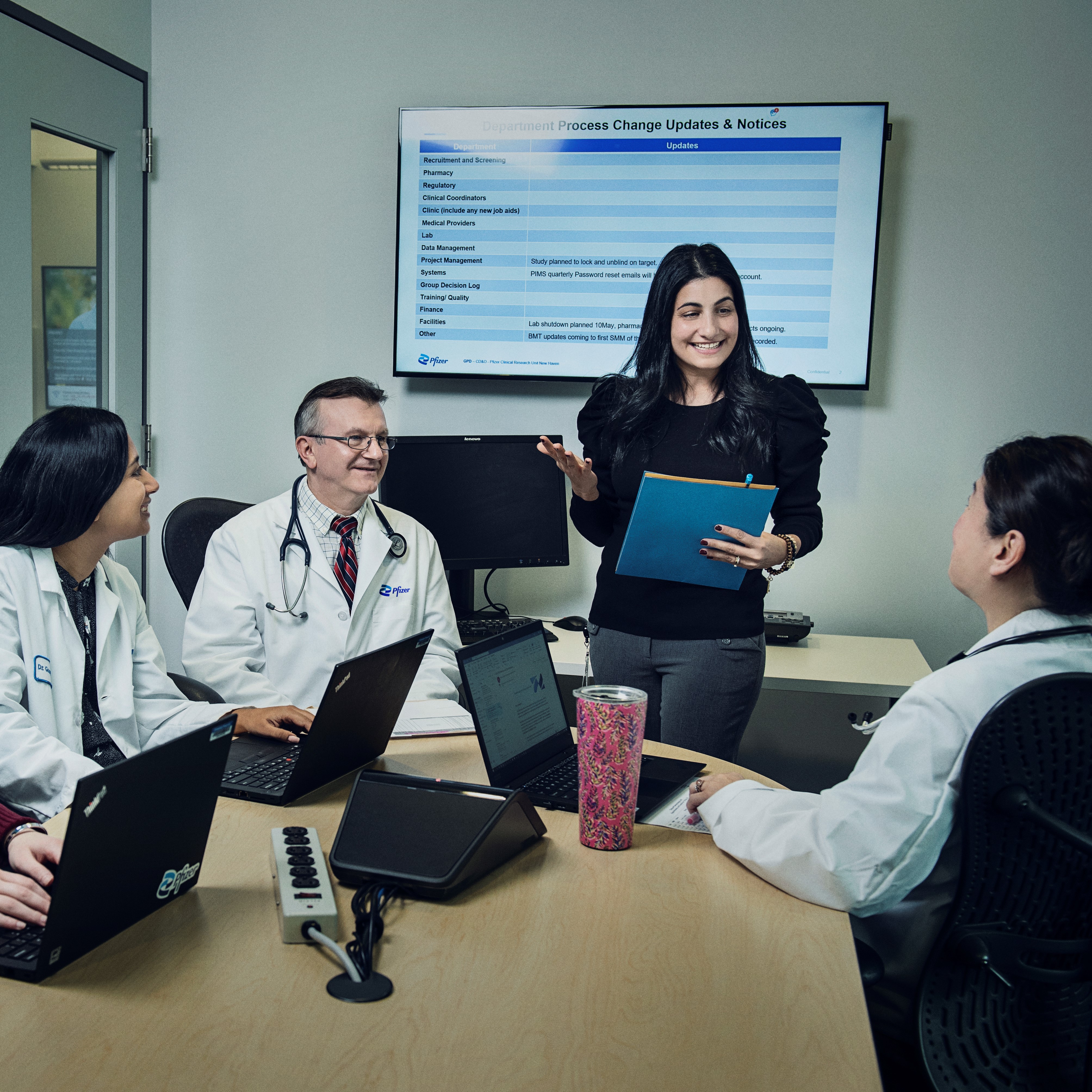 clinical trial staff talking in a small meeting room