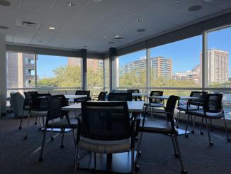 Tables and chairs organized in small groups for vaccine clinical trial participants at the New Haven PCRU.