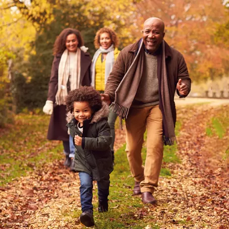 A three-generation African American family walking through woodland – Pfizer Clinical Trials