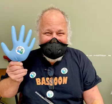 Pfizer vaccine clinical trial participant Jeff posing with balloon glove