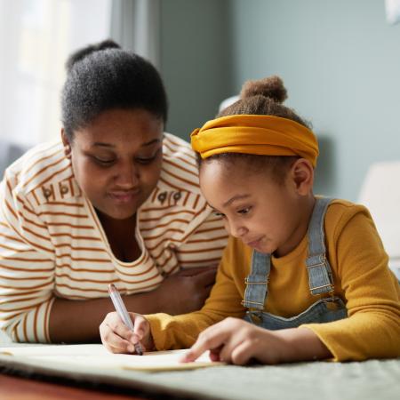 Child drawing while mom looks  – Pfizer Clinical Trials