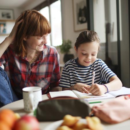 Mujer con su hija haciendo tareas – Estudios Clínicos de Pfizer