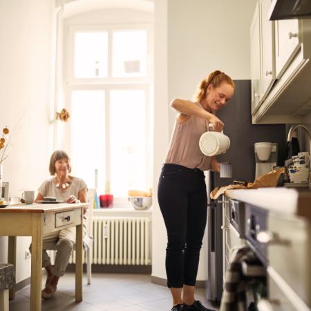 Woman pouring hot beverage for grandmother – Pfizer Clinical Trials