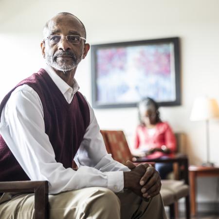 Picture of a man sitting in a waiting room– Pfizer Clinical Trials