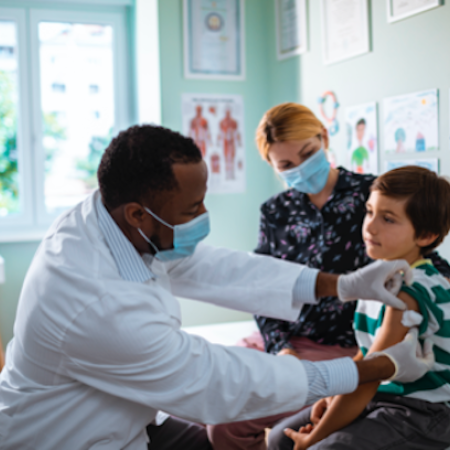 Proveedor de atención médica aplicando una inyección a un paciente pediátrico