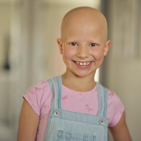 niña sonriendo a la cámara: Estudio clínico de Pfizer