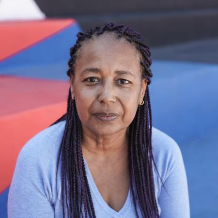 Woman with braided hair looking directly forward – Pfizer Clinical Trials